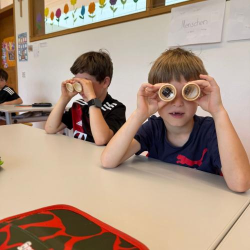 Die Kinder werfen einen Blick durch das "Bienenaugen"-Glas
