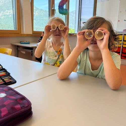 Die Kinder werfen einen Blick durch das "Bienenaugen"-Glas