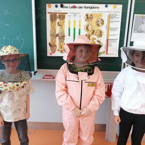 Die Kinder probieren den Imkeranzug an.