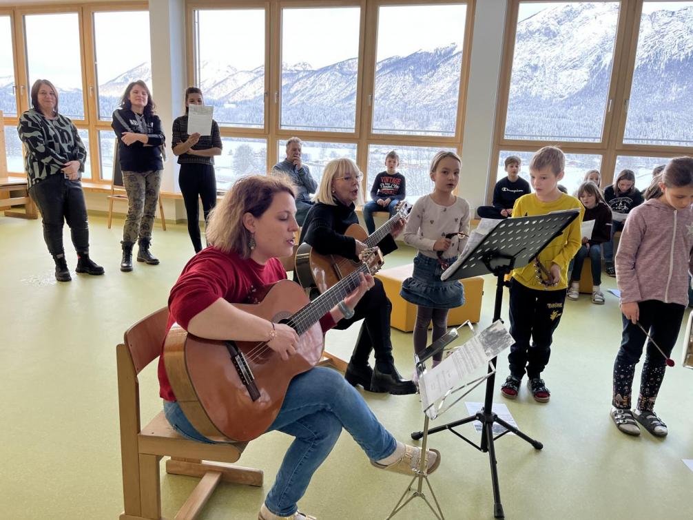 Unsere Religionslehrerin spielt mit der Gitarre, die Kinder singen mit