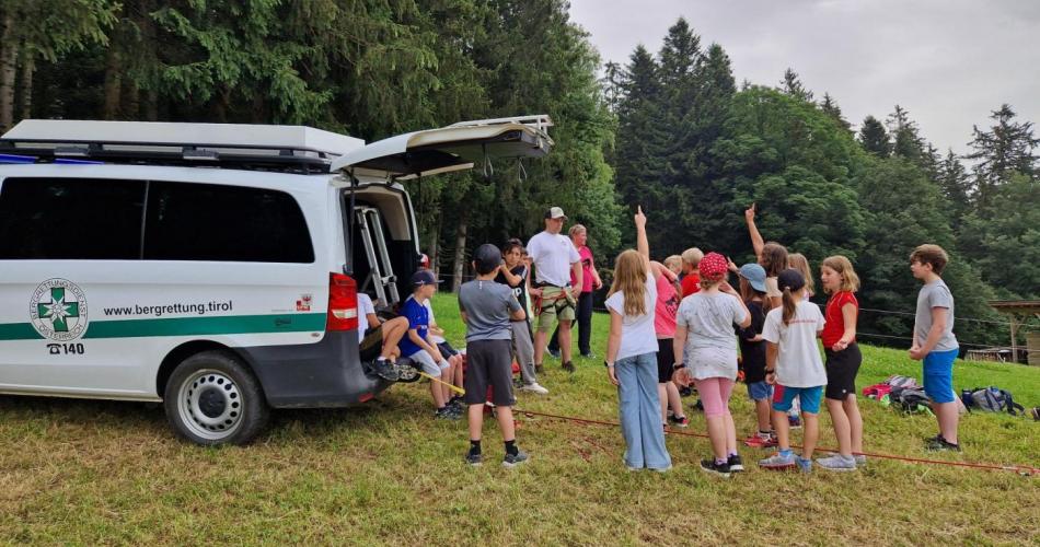 Kinder stehen rund um das Bergrettungsauto
