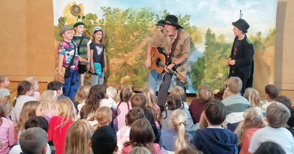 Toni Tanner singt mit Kindern auf der Bühne